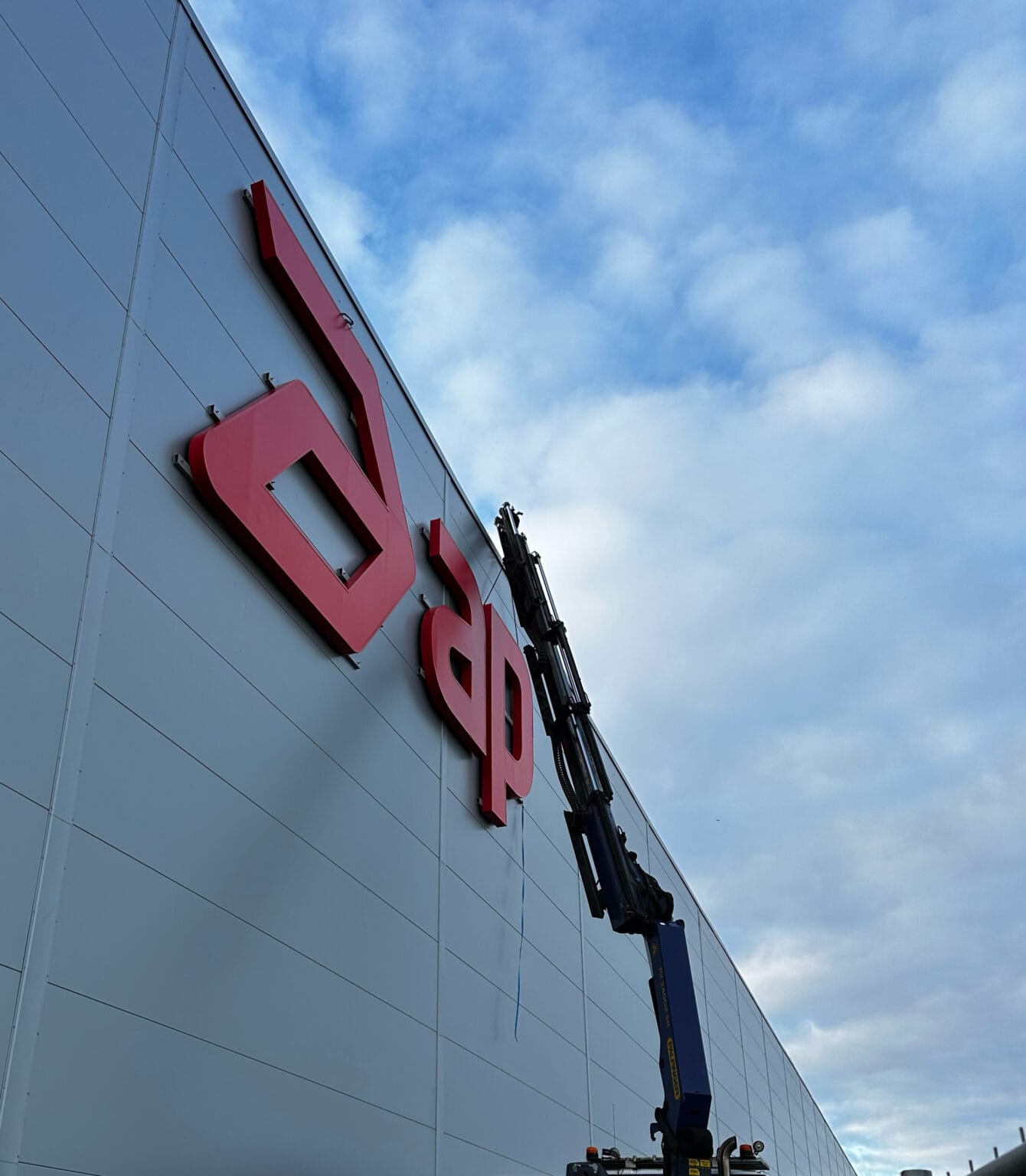 Montage av stor apotea skyltbokstav på fasad, Skylttillverkning